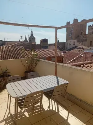 a table and chairs on a balcony with a view at Studio Corneille -Climatisation WIFI Vue in Narbonne