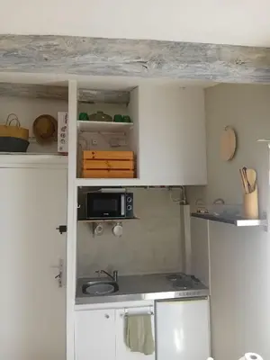 a small kitchen with white cabinets and a microwave at Studio Corneille -Climatisation WIFI Vue in Narbonne