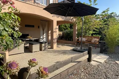 a patio with a table and an umbrella at Les hauts d'Embres havre de paix pour 8 in Embres-et-Castelmaure