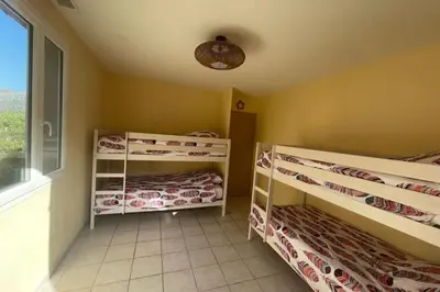 two bunk beds in a room with a window at Les hauts d'Embres havre de paix pour 8 in Embres-et-Castelmaure