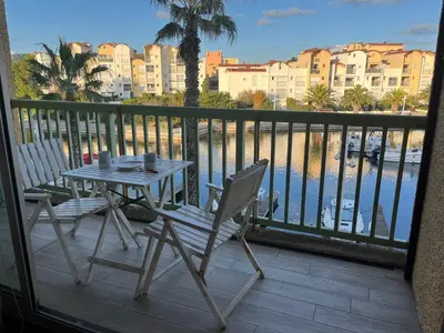 a table and chairs on a balcony with a view of the water at Gruissan - T2 cosy 4 pers - Proche port - FR-1-796-95 in Gruissan
