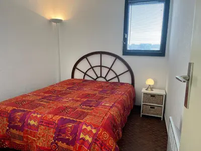 a bedroom with a bed with a red blanket and a window at Gruissan - T2 cosy 4 pers - Proche port - FR-1-796-95 in Gruissan
