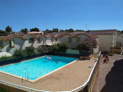 a swimming pool in front of a house at Gruissan - T2 cosy 4 pers - Proche port - FR-1-796-95 in Gruissan