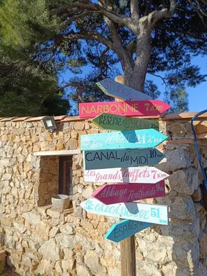 a street sign with arrows pointing in different directions at Studio terrasse au calme près de Narbonne in Montredon