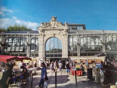 a large building with people walking around a market at Studio terrasse au calme près de Narbonne in Montredon