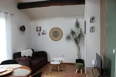 a living room with a couch and a table at La petite maison in Cuxac-Cabardès