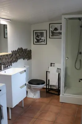 a bathroom with a toilet and a sink and a shower at La petite maison in Cuxac-Cabardès