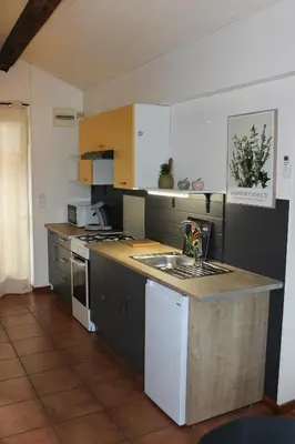 a kitchen with a sink and a counter top at La petite maison in Cuxac-Cabardès