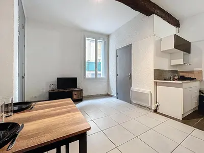 a large kitchen with a table in a room at Le Baudinet - Studio - Centre Ville - Rez-de-Chaussée in Narbonne