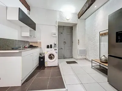 a white kitchen with a washing machine in it at Le Baudinet - Studio - Centre Ville - Rez-de-Chaussée in Narbonne