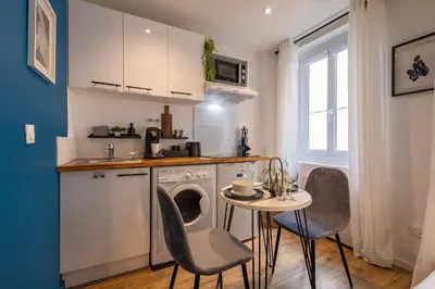 a kitchen with a table and chairs and a sink at L'indigo - Studio Apaisant et Lumineux, Hyper centre in Castres