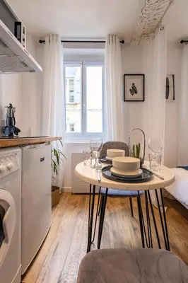 a kitchen and living room with a table with glasses on it at L'indigo - Studio Apaisant et Lumineux, Hyper centre in Castres