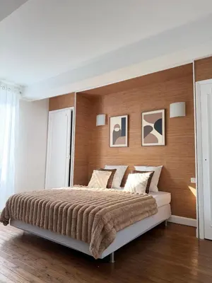 a bedroom with a large bed with a wooden wall at Domaine de Hauterive in Pont-de-Larn