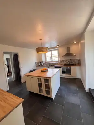 a kitchen with white cabinets and a tile floor at Domaine de Hauterive in Pont-de-Larn