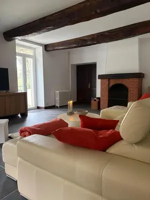 a living room with a white couch and a fireplace at Domaine de Hauterive in Pont-de-Larn