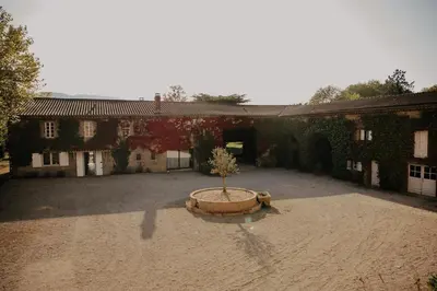 a courtyard with a tree in the middle of a building at Domaine de Hauterive in Pont-de-Larn