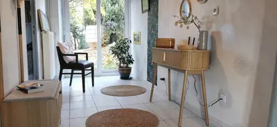a living room with a table and a chair at la chambre gourmande, en Richard in Auriac-sur-Vendinelle