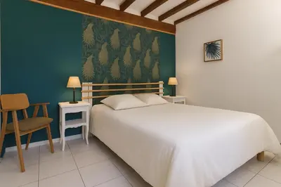 a bedroom with a white bed and a green wall at la chambre gourmande, en Richard in Auriac-sur-Vendinelle