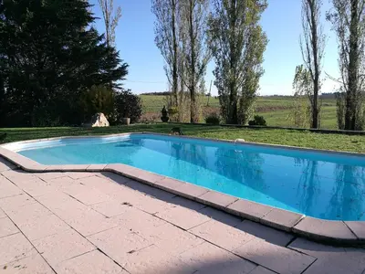 a swimming pool with a brick walkway around it at la chambre gourmande, en Richard in Auriac-sur-Vendinelle