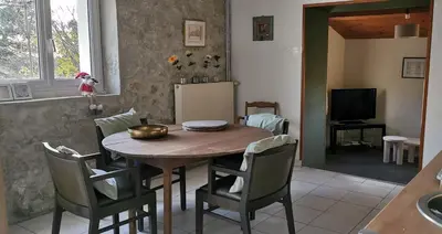 a kitchen and dining room with a wooden table and chairs at la chambre gourmande, en Richard in Auriac-sur-Vendinelle