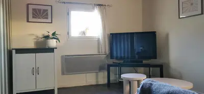 a living room with a television on a table at la chambre gourmande, en Richard in Auriac-sur-Vendinelle