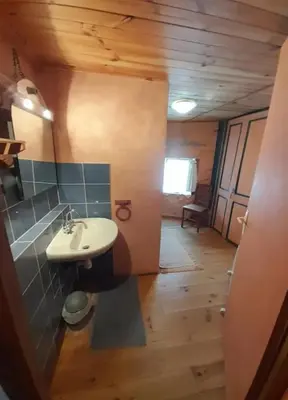 a bathroom with a white sink and a wooden floor at Maison au pied de la Montagne Noire proche Carcassonne in Cassagnolles