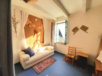 a living room with a couch and a window at Maison au pied de la Montagne Noire proche Carcassonne in Cassagnolles