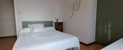a small bedroom with a bed with white sheets at Grand gîte proche des lacs in Prémian