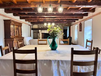 a dining room with a table with a vase of flowers at Grand gîte proche des lacs in Prémian