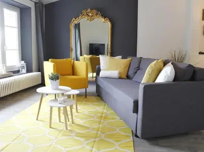 a living room with a blue couch and yellow chairs at Maison Bacou cité 2 in Carcassonne