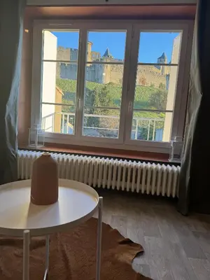 a room with a table and a window with a view at Maison Bacou cité 2 in Carcassonne