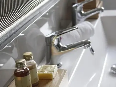 a sink with a bottle of soap and a faucet at Maison Bacou cité 2 in Carcassonne