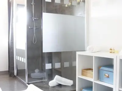 a bathroom with a shower with a glass door at Maison Bacou cité 2 in Carcassonne