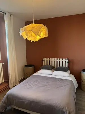 a bedroom with a large bed with a yellow light at Maison Bacou cité 2 in Carcassonne