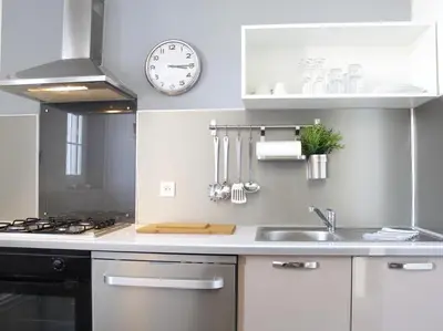a kitchen with a sink and a clock on the wall at Maison Bacou cité 2 in Carcassonne