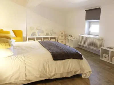 a bedroom with a large white bed and a window at Maison Bacou cité 2 in Carcassonne