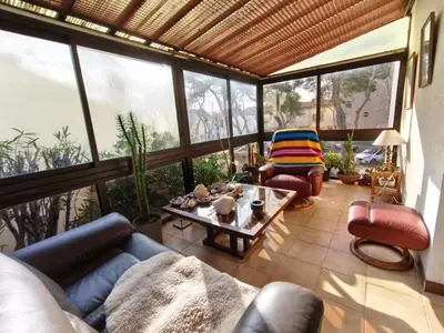 a living room with couches and a table and windows at La 1848 Narbonnaise in Narbonne