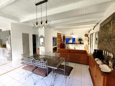 a dining room and living room with a glass table and chairs at La 1848 Narbonnaise in Narbonne