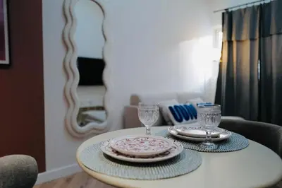 a table with two plates and wine glasses on it at Maison Franz - 800m des Grands Buffets - Garage in Narbonne
