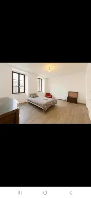 a large room with two beds and a desk at Appartement avec deux chambres et salon de massage in Lavelanet