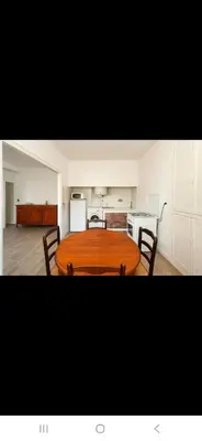a kitchen with a table and chairs in a room at Appartement avec deux chambres et salon de massage in Lavelanet