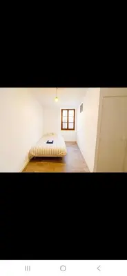 a bedroom with a bed in the corner of a room at Appartement avec deux chambres et salon de massage in Lavelanet