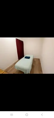 a small room with a bed with a white blanket at Appartement avec deux chambres et salon de massage in Lavelanet