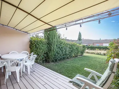 a wooden deck with white chairs and a table at PMinervois I N02 Villa 3P6 in Homps