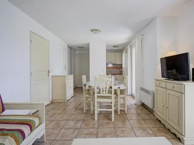 a living room with a table and chairs and a tv at P Minervois L N02 Villa 3P6 in Homps
