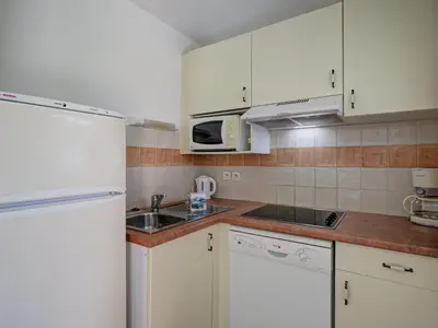 a kitchen with white cabinets and a sink and a microwave at P Minervois L N02 Villa 3P6 in Homps