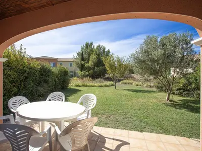 a patio with a table and chairs and a yard at P Minervois L N02 Villa 3P6 in Homps