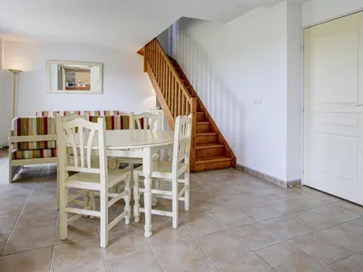 a dining room with a table and chairs and a staircase at P Minervois S N06 Villa 4P8 in Homps