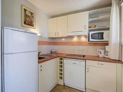 a kitchen with white cabinets and a refrigerator at P Minervois S N06 Villa 4P8 in Homps