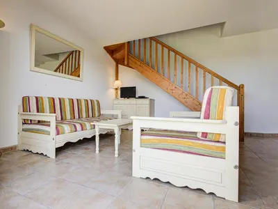 a living room with two chairs and a staircase at P Minervois S N06 Villa 4P8 in Homps